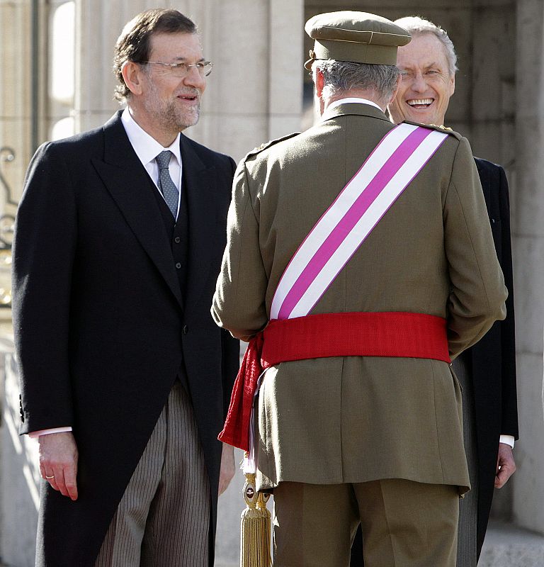 El rey Juan Carlos conversa con el presidente del Gobierno, Mariano Rajoy (i), y el ministro de Defensa, Pedro Morenés, en la Plaza de la Armería del Palacio Real.BIERNO