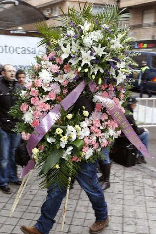 Una corona de flores enviada por el Partido Popular es trasladada hasta la capilla ardiente de Manuel Fraga.