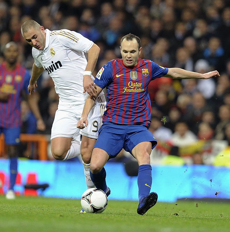 Barcelona's Iniesta is challenged by Real Madrid's Benzema during their Spanish King's Cup soccer match in Madrid