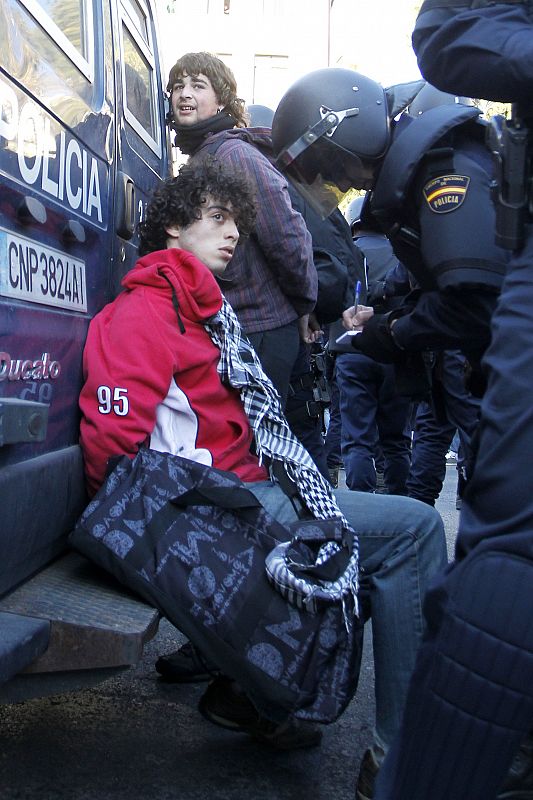 Un policía toma los datos de unos de los detenidos en las protestas estudiantiles de Valencia.