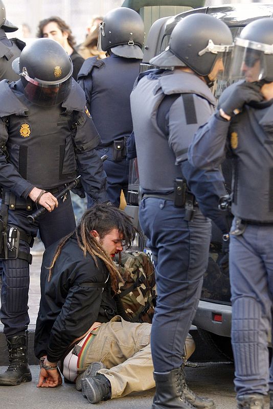 La policia custodia a un detenido durante los incidentes entre estudiantes y policias registrados en el centro de Valencia.