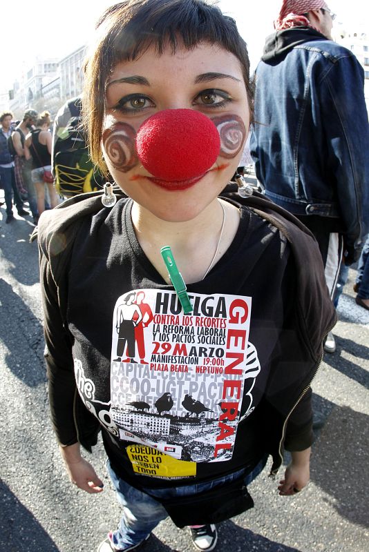 Una joven participa vestida de payaso en plena Plaza de Cibeles de Madrid.