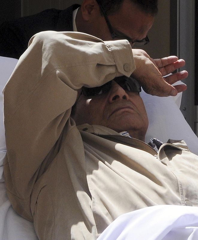 Former Egyptian President Hosni Mubarak is wheeled out of the courtroom in Cairo