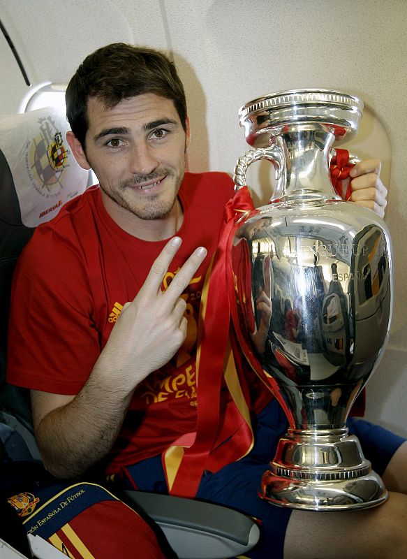 El guardameta y capitán de la selección española de fútbol, Iker Casillas, posa con la copa de campeones de la Eurocopa 2012, en el avión que trasladó al equipo español desde Kiev a Madrid.