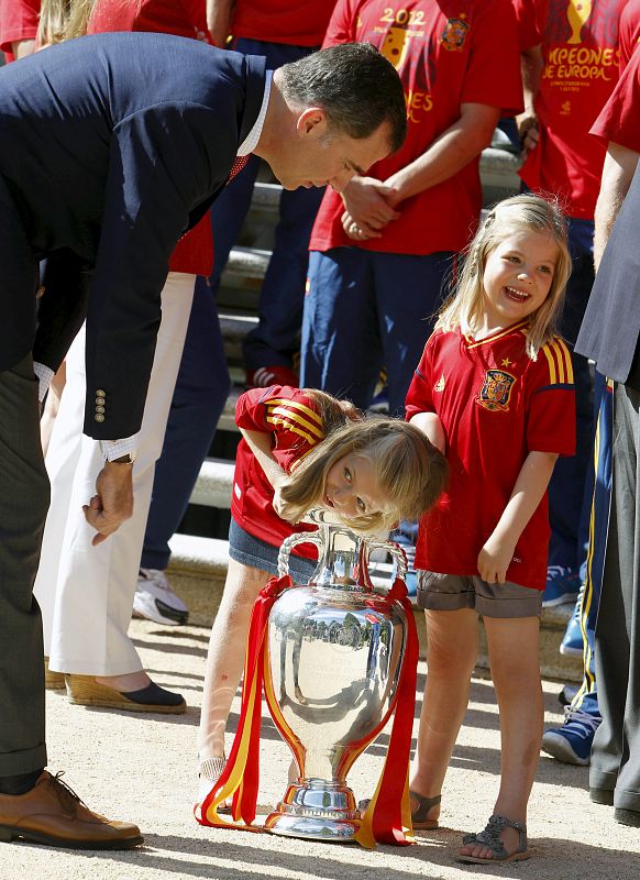 El príncipe Felipe y sus hijas, Leonor y Sofía, observan la Copa conseguida en Kiev.