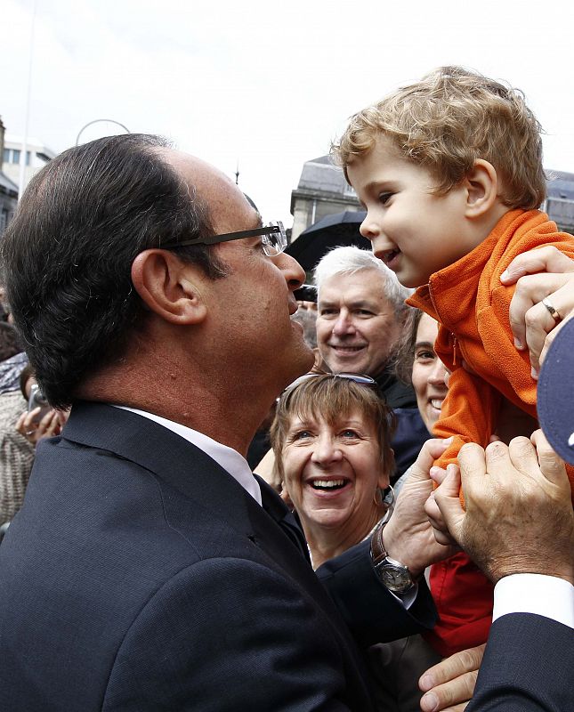 France's President Hollande kisses a child as he attends an anniversary ceremony of a reconciliation meeting after World War II, in Reims