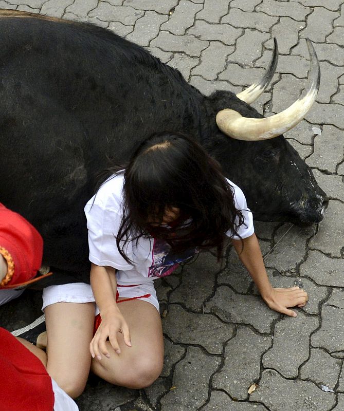 Un morlaco pone en apuro a una joven en el tramo del Callejon antes de entrar a la plaza de toros