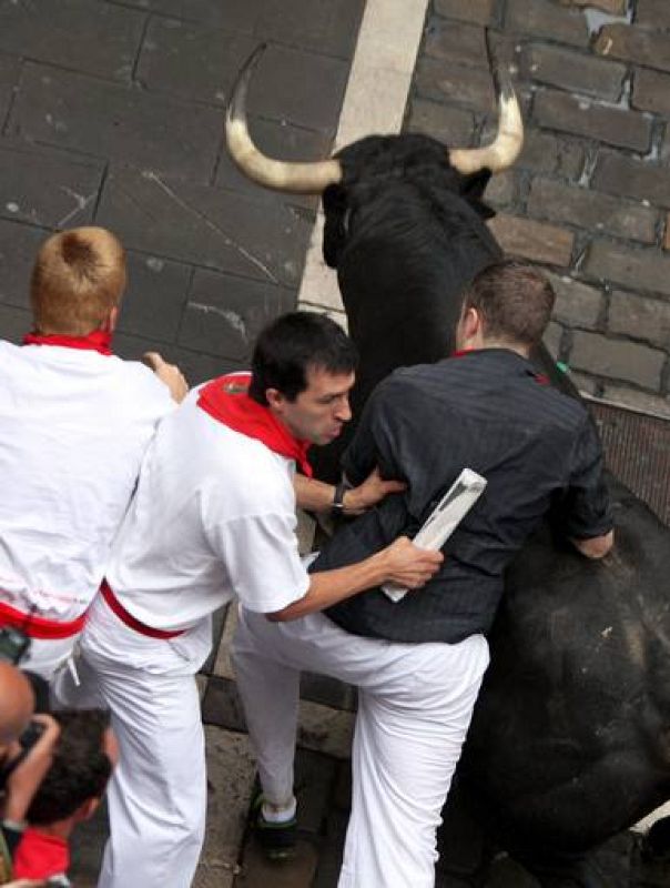 Uno de los toros junto a los corredores en la jornada mas accidentada hasta el momento de los sanfermines 2012
