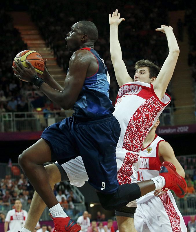 Great Britain's Deng gets past Russia's Karasev during their men's Group B basketball match at the London 2012 Olympic Games in the Basketball arena