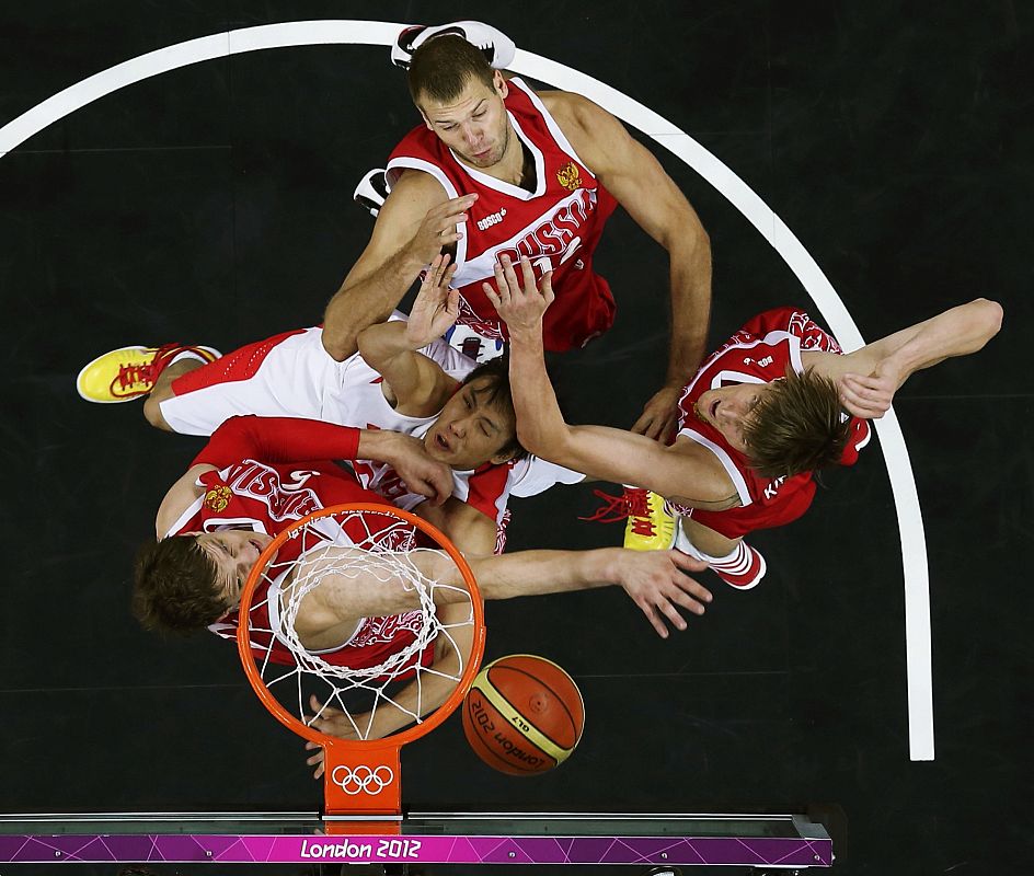 El chino Yi Li intenta bloquear  debajo de la canasta al ruso.