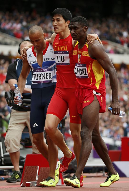 Liu Xiang con la ayuda de Andrew Turner de Gran Bretaña y Jackson Quiñónez de España después de sufrir las lesiones  durante la prueba de obstáculos de 110m de los Juegos.