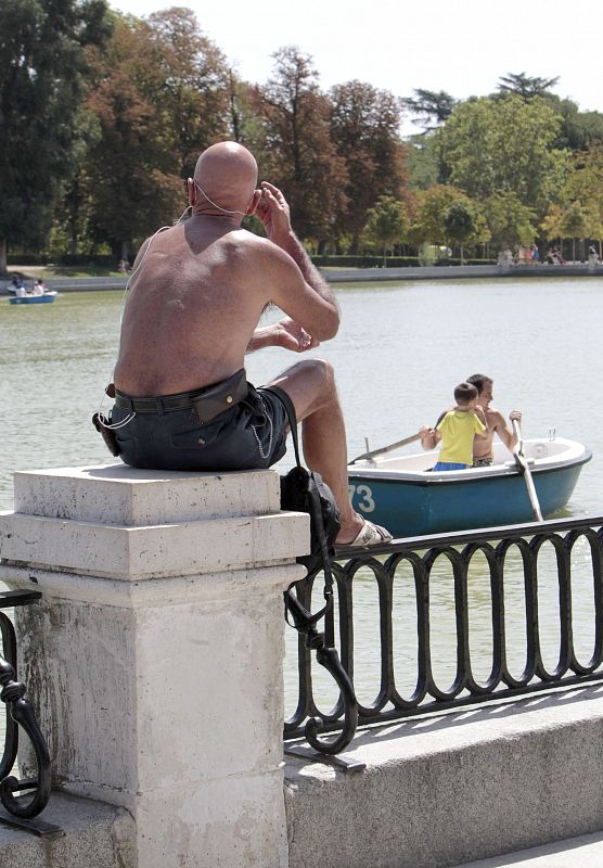 Un hombre sin camiseta junto al estanque del Retiro en Madrid