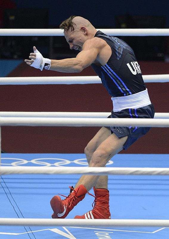 El boxeador ucraniano Denys Berinchyk (azul) celebra tras ganar a Munkh-Erdene Uranchimeg de Mongolia (rojo) la semifinal masculina de peso welter ligero 64Kg.