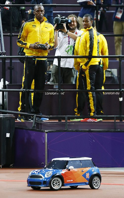 El atleta jamaiquino Usain Bolt prueba el mini automóvil que se usa para llevar las jabalinas o los discos en las pruebas atléticas después de ganar ayer la prueba de relevos 4x100m de atletismo.