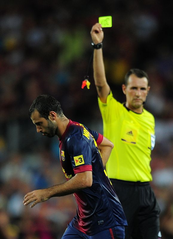 El arbitro aragonés, Clos Gómez, le muestra tarjeta amarilla a Mascherano, jugador del F.C. Barcelona.