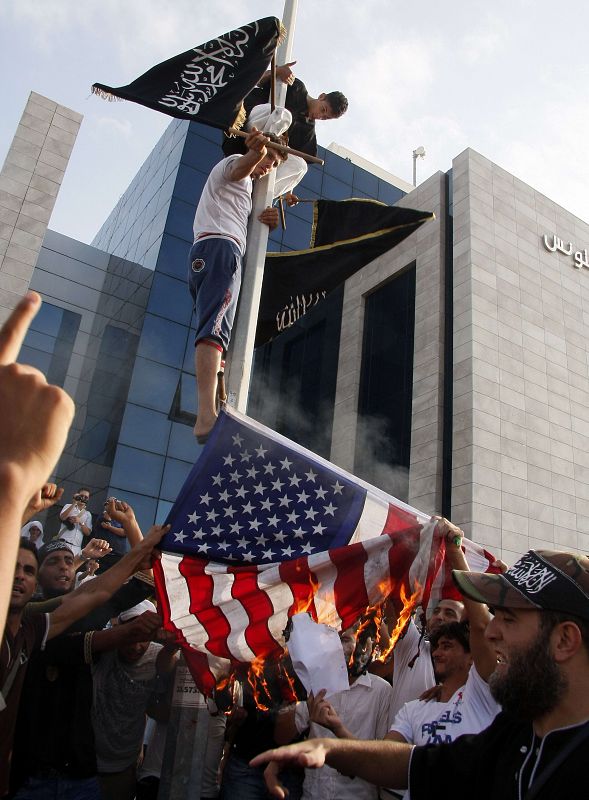 Manifestantes reemplazan una bandera de las barras y estrellas por una enseña islámica ante la embajada americana en Túnez