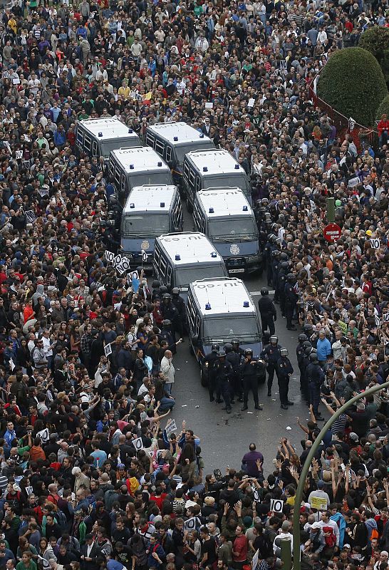 Los manifestantes rodean las furgonetas de la policía.