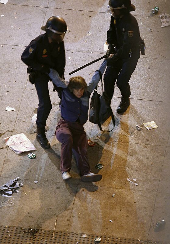 Protester is dragged away by police during demonstration outside the Spanish parliament in Madrid