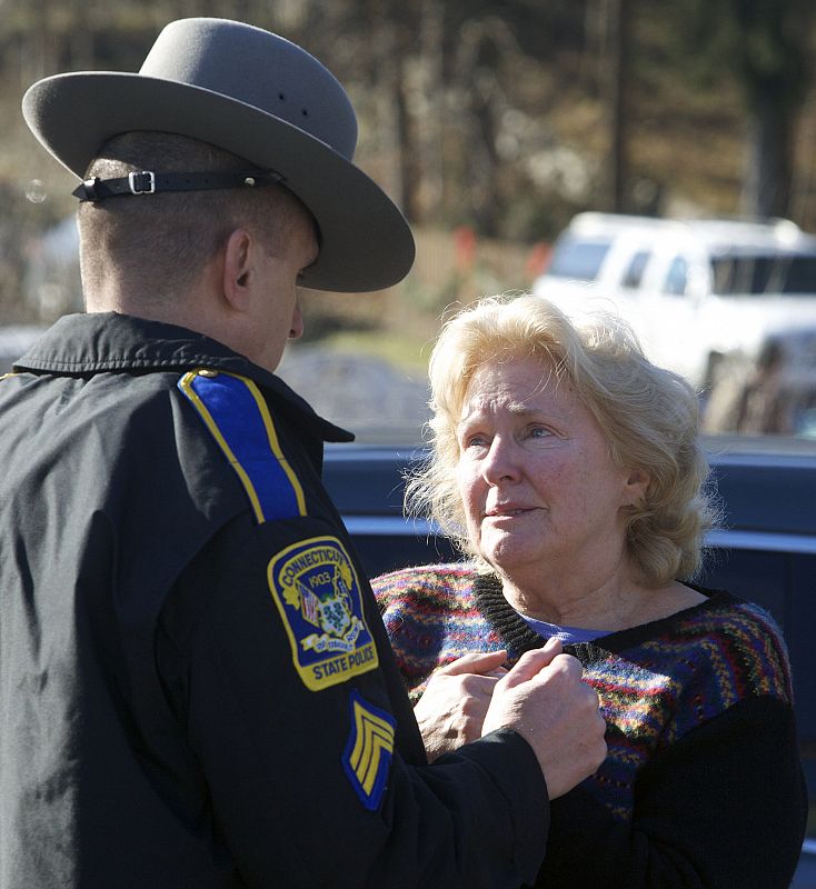 Una mujer habla con una agente de la autoridad fuera del colegio de Newtown