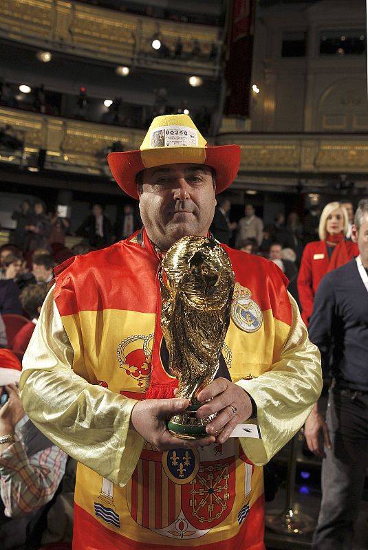 Un madridista envuelto en la bandera de España espera que la copa del Mundo del fútbol le dé suerte.