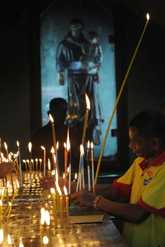 Un cristiano enciende una vela durante la Misa del Gallo en Colombo, Sri Lanka