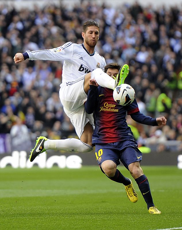 Sergio Ramos (I) pelea por el balón con Lionel Messi.