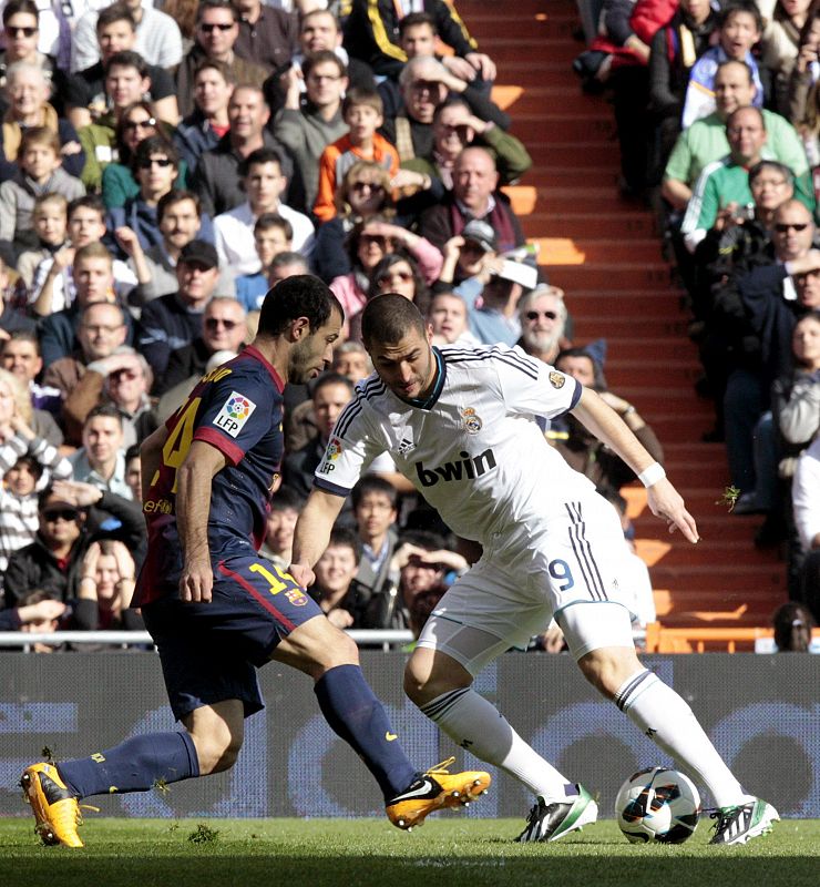 Benzema (d) disputa el balón al jugador argentino del Barcelona Javier Mascherano.