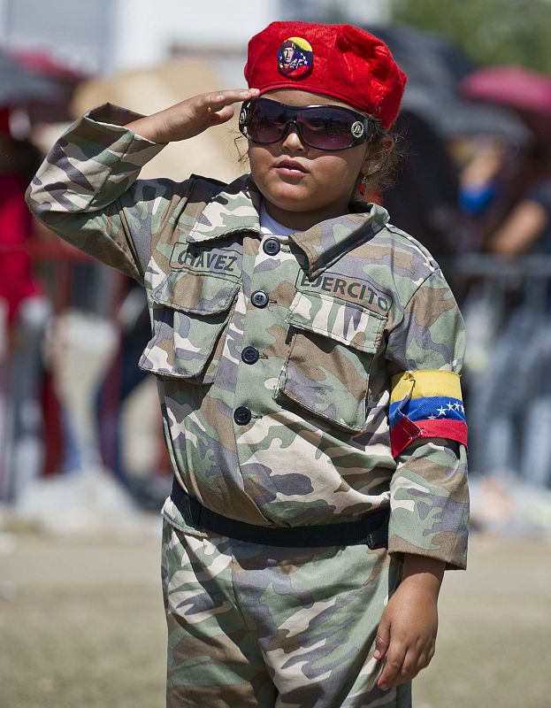 Una niña venezolana, vestida como el comandante Chávez, hace un saludo militar en la jornada del funeral en la Academia Militar de Caracas