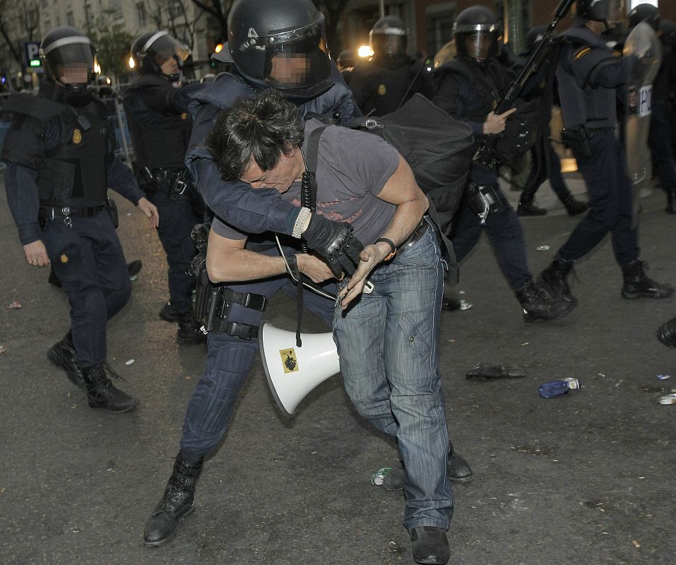 Un manifestante es detenido por un policía nacional  en la plaza de Neptuno.