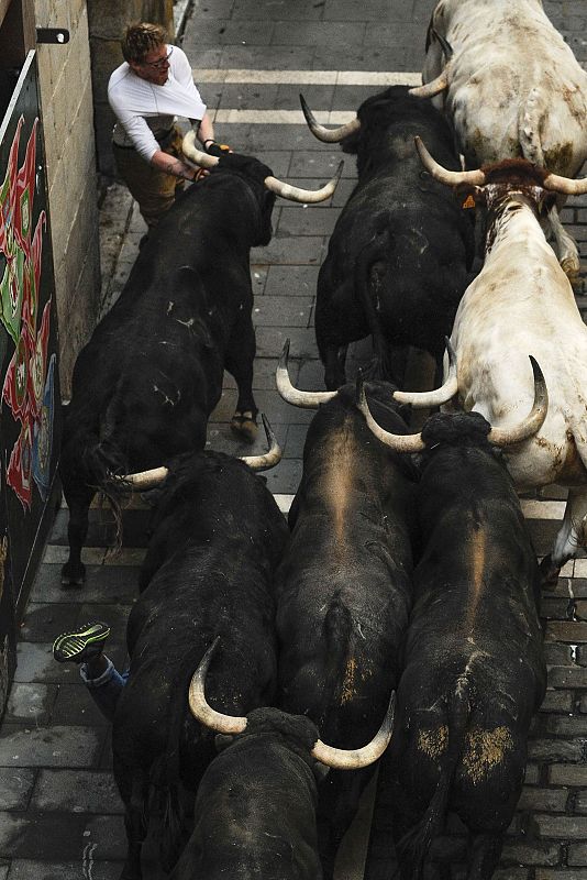Un corredor de pantalon marrón y camiseta blanca ha sido arrollado por los toros de Victoriano Cortés a su paso por la calle Estafeta