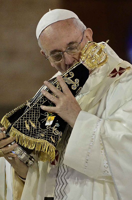 El papa besa una réplica de la Virgen de Aparecida antes de oficiar su primera misa como pontífice en Brasil.