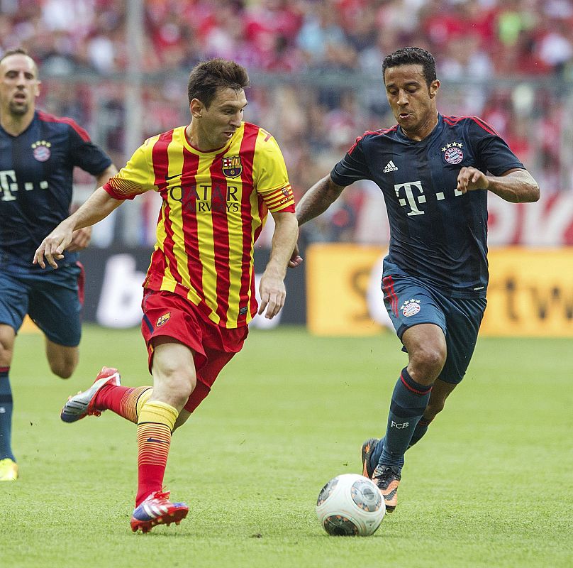 El jugador del Bayern Múnich Thiago trata de robar el balón al jugador argentino del FC Barcelona Lionel Messi.