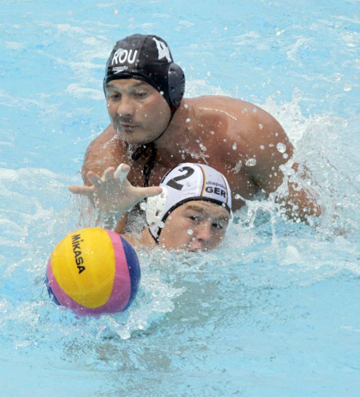 El waterpolista alemán Denis Eidner (abajo) y el rumano Nicolae Diaconu (arriba) luchan por el balón durante el partido.