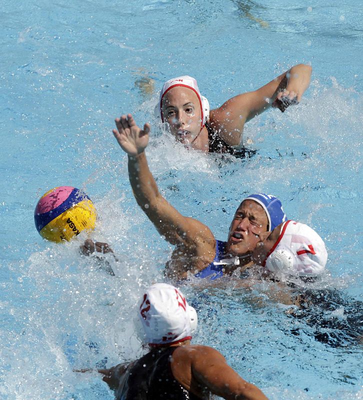 La waterpolista griega Alexandra Asimaki lucha por el el balón ante las canadienses Joelle Bekhai y Marina Radu (zona inferior de la imagen) durante el partido correspondiente a la fase preliminar de los Campeonatos del Mundo.