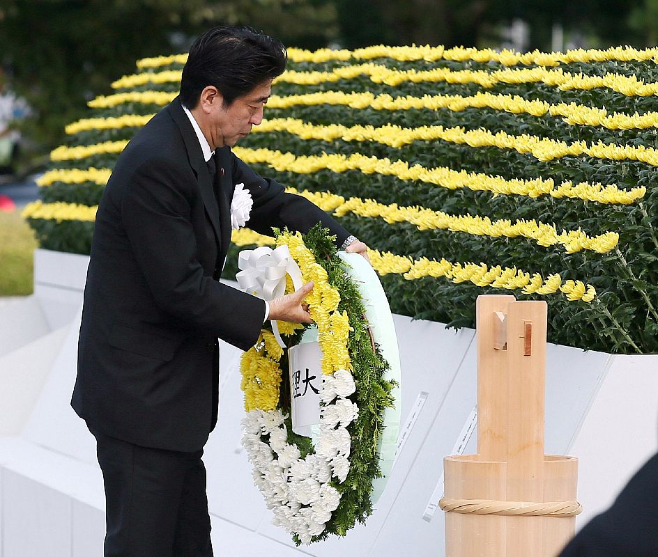 El primer ministro japonés Shinzo Abe pone una corona de flores en el altar de las víctimas de la bomba atómica en el Parque Memorial de la Paz de Hiroshima.