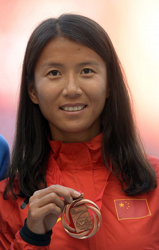 La atleta china Hong Liu posa con su medalla de bronce en el podio.