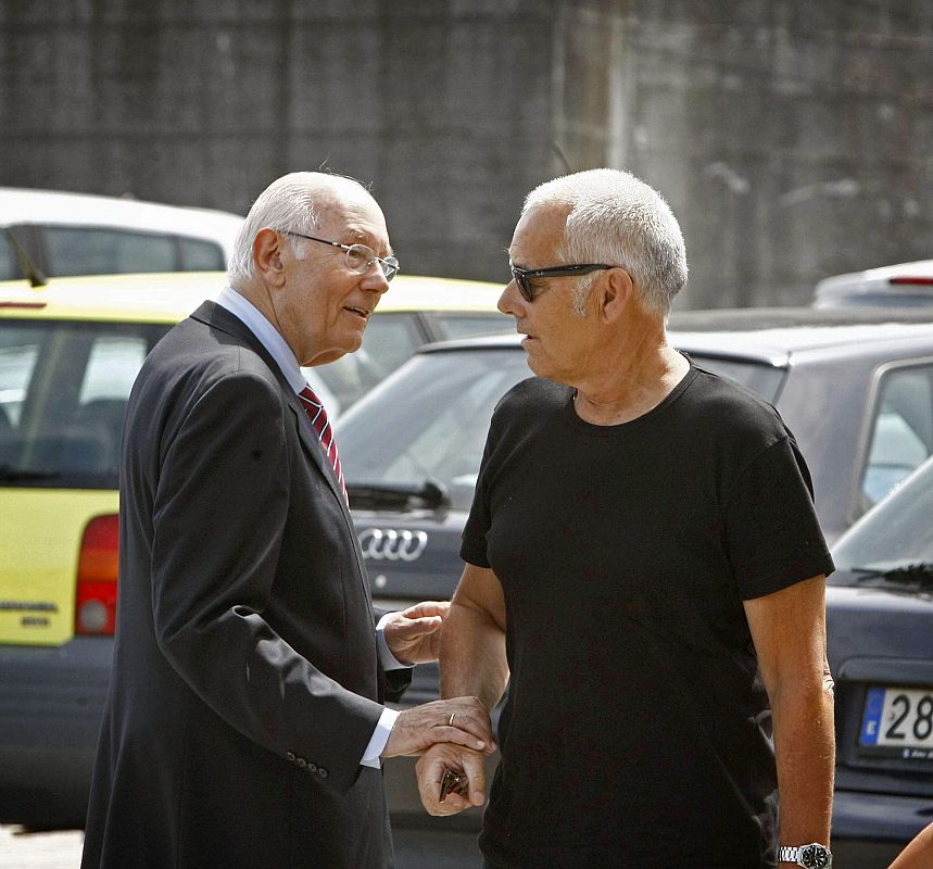 El presidente del Consejo de Estado, Romay Beccaría (i), acompañado por el diseñador de moda, Antonio Pernas (d), se saludan a la entrada del tanatorio.