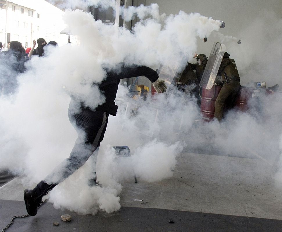 Un grupo de encapuchados se enfrenta a los antidisturbios chilenos durante las protestas que han sucedido a la marcha en conmemoración del Golpe de Estado que acabó con el Gobierno y la vida de Salvador Allende