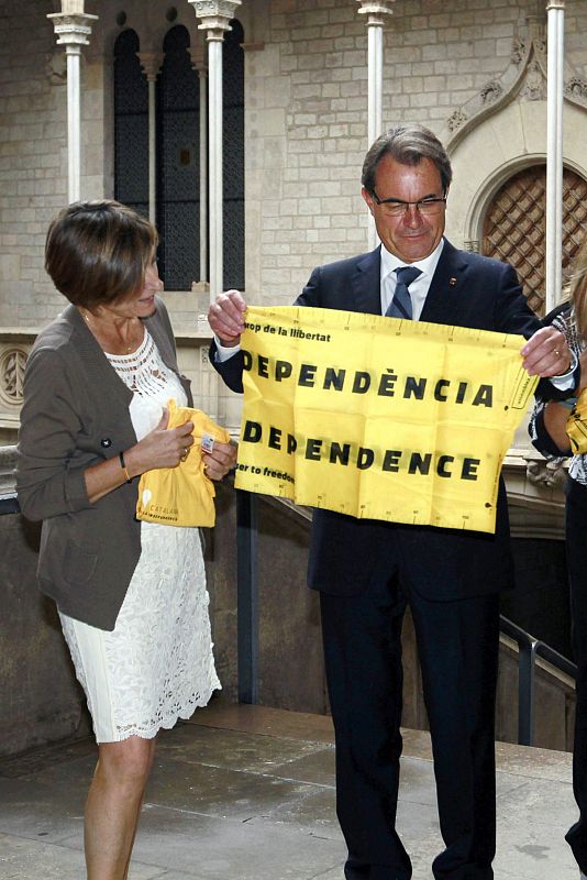 El presidente de la Generalitat muestra un cartel por la independencia durante la reuníon que ha mantenido con la presidenta de la Asamblea Nacional Catalana (ANC).