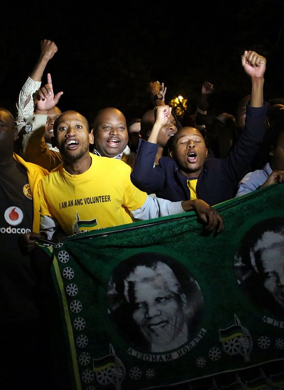 Un grupo de ciudadanos honra la memoria de Nelson Mandela frente a la casa en la que ha fallecido en Johannesburgo