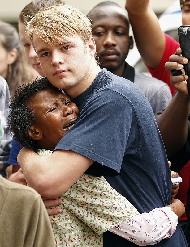 Dos personas de diferente raza se abrazan en Johannesburgo tras la muerte de Mandela, que acabó con el 'apartheid'.