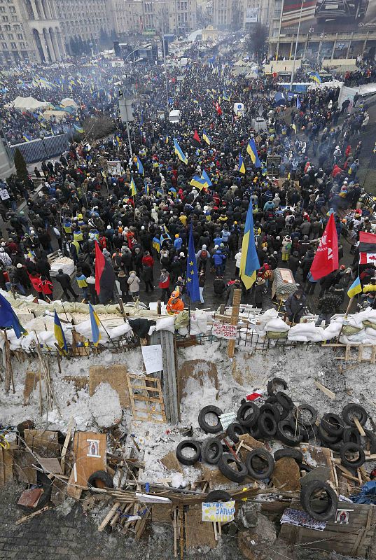 Pro-European intergration protesters stand behind a barricade at Independence Square in Kiev