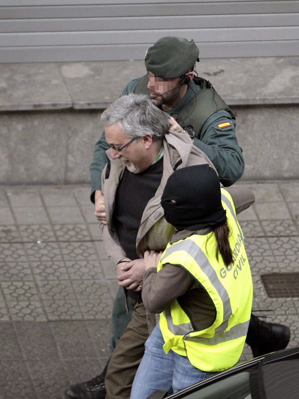 Agentes conducen a uno de los ocho detenidos en la calle Elcano de Bilbao.