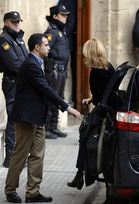 La hija menor del rey bajando del vehículo cerca de la puerta de los juzgados.