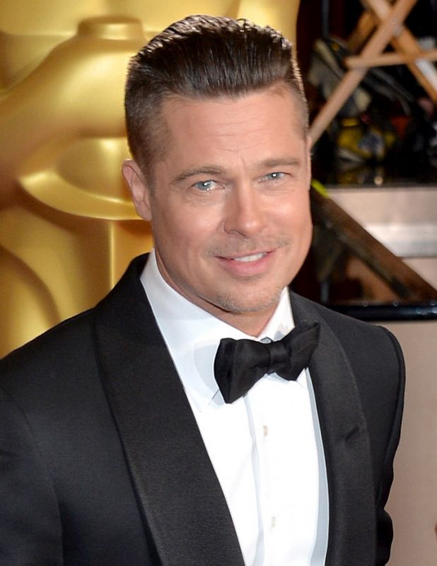 El actor y productor Brad Pitt saluda a la prensa en su llegada a la ceremonia de los Oscar 2014.