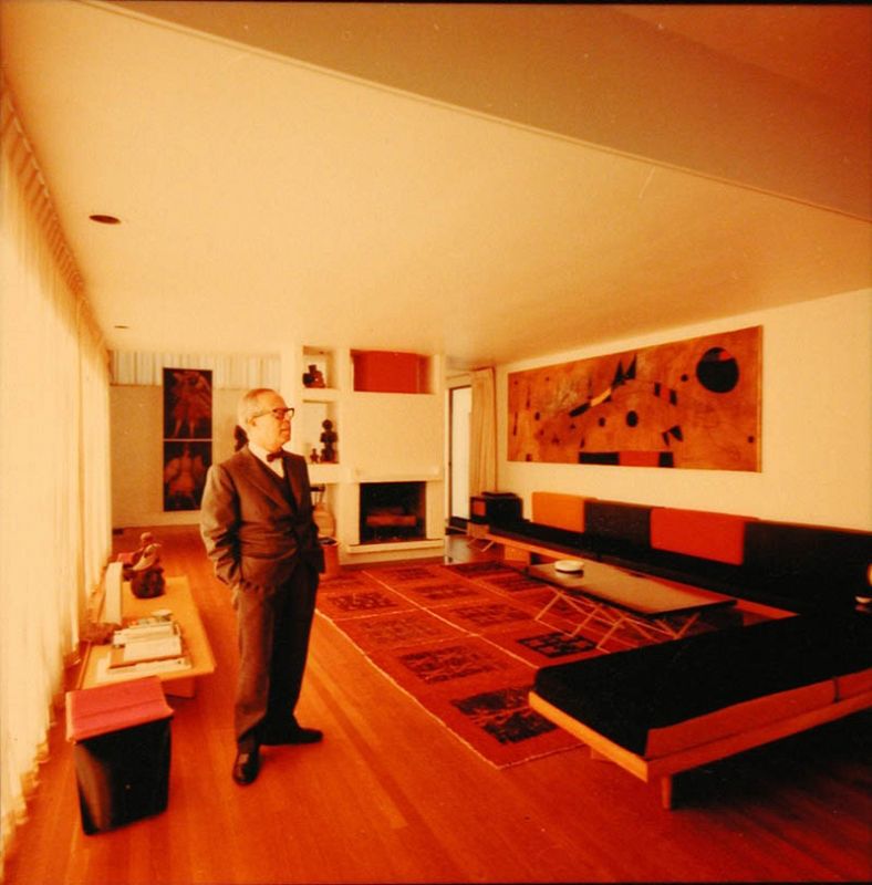 El arquitecto Josep Lluís Sert contempla el mural realizado por el pintor Joan Miró, en el salón de su casa en Cambridge, en el recinto de la Universidad de Harvard, cerca de Boston, en Estados Unidos.