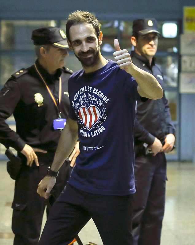 El defensa del Atlético de Madrid Juanfran saluda a los aficionados colchoneros en su llegada al aeropuerto Adolfo Suárez - Madrid Barajas