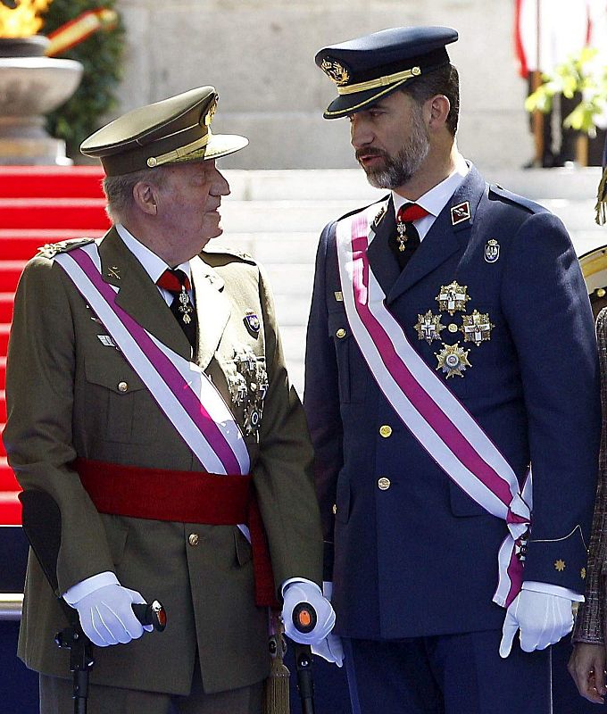 El Rey Juan Carlos conversa con el Príncipe de Asturias en la celebración del Día de las Fuerzas Armadas en 2013