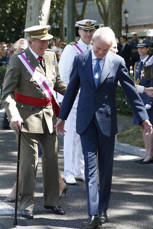 El rey junto al ministro de Defensa, Pedro Morenés, llega a la madrileña plaza de la Lealtad para presidir junto el Día de las Fuerzas Armadas.