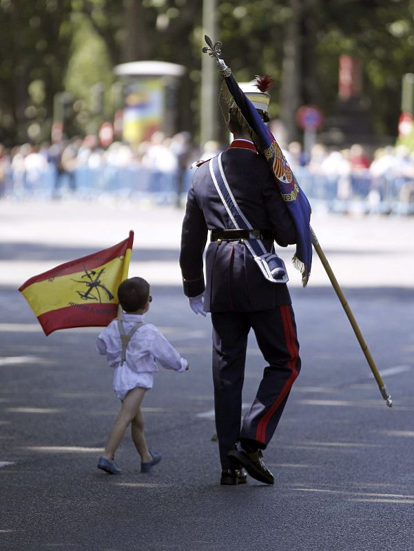 Un guardia real llega con su hijo de corta edad a la Plaza de la Lealtad, en Madrid.